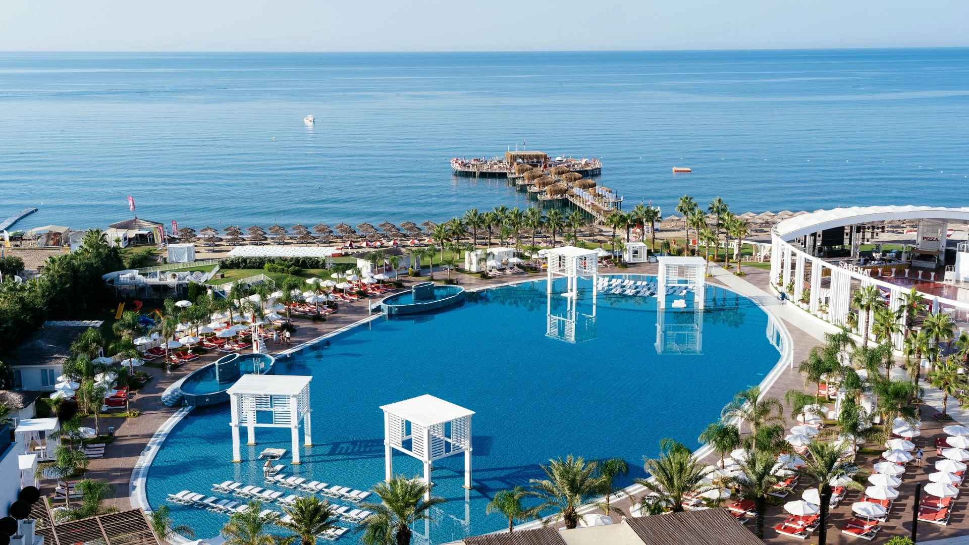Hauptpool des Selectum Luxury Resort Belek mit Liegen und Sonnenschirmen
