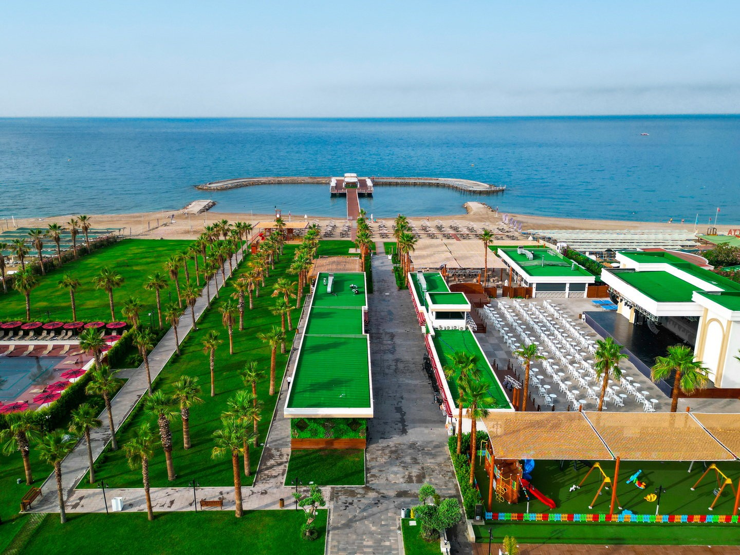 Strandbereich des Serenity Queen Hotels mit Badesteg und Gartenanlage