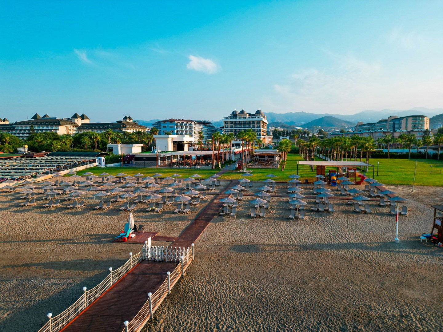 Hoteleigener Strand des Serenity Queen Hotels mit Liegen und Sonnenschirmen