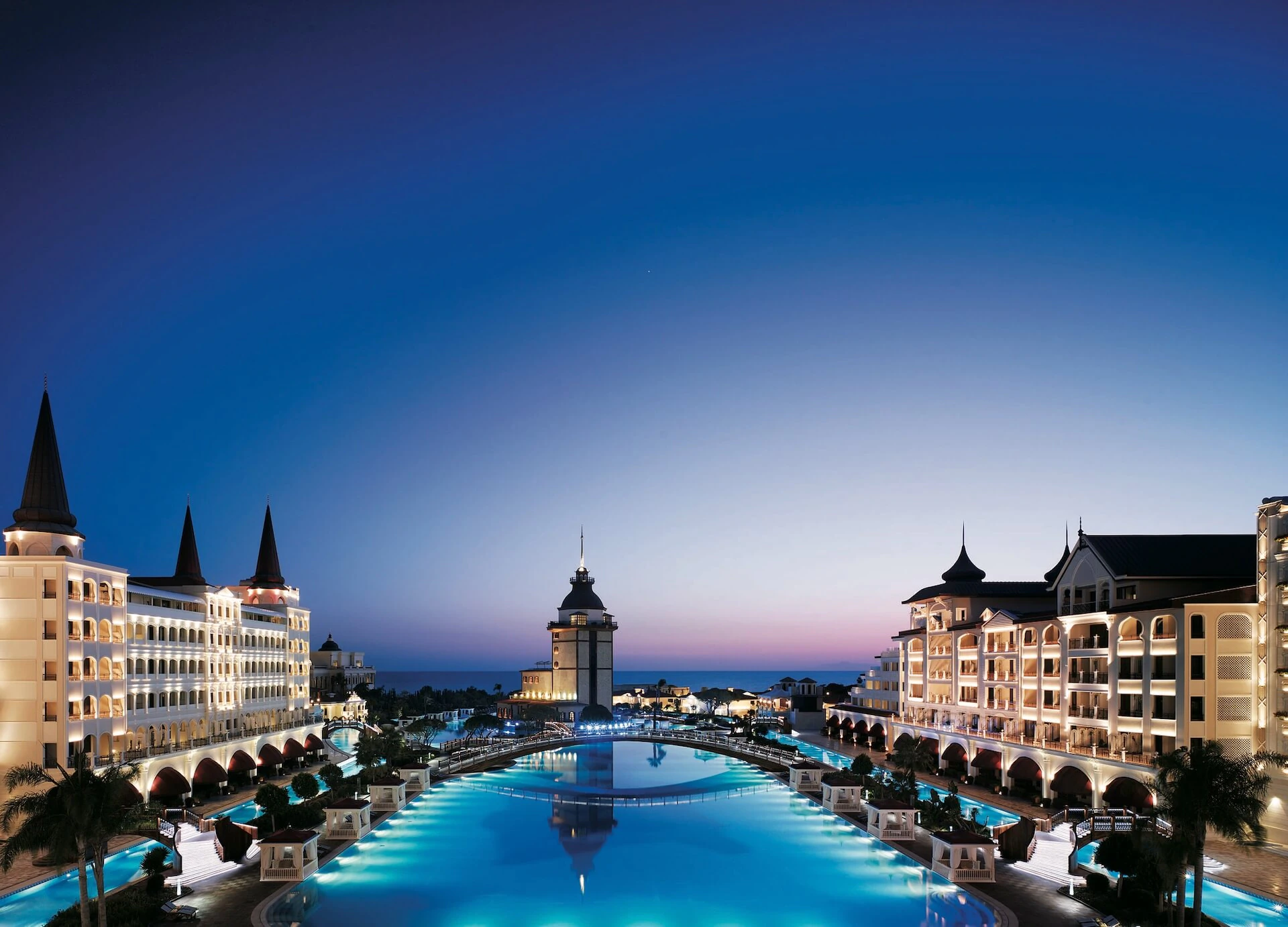 Mardan Palace mit beleuchteter Poollandschaft in der Abenddämmerung