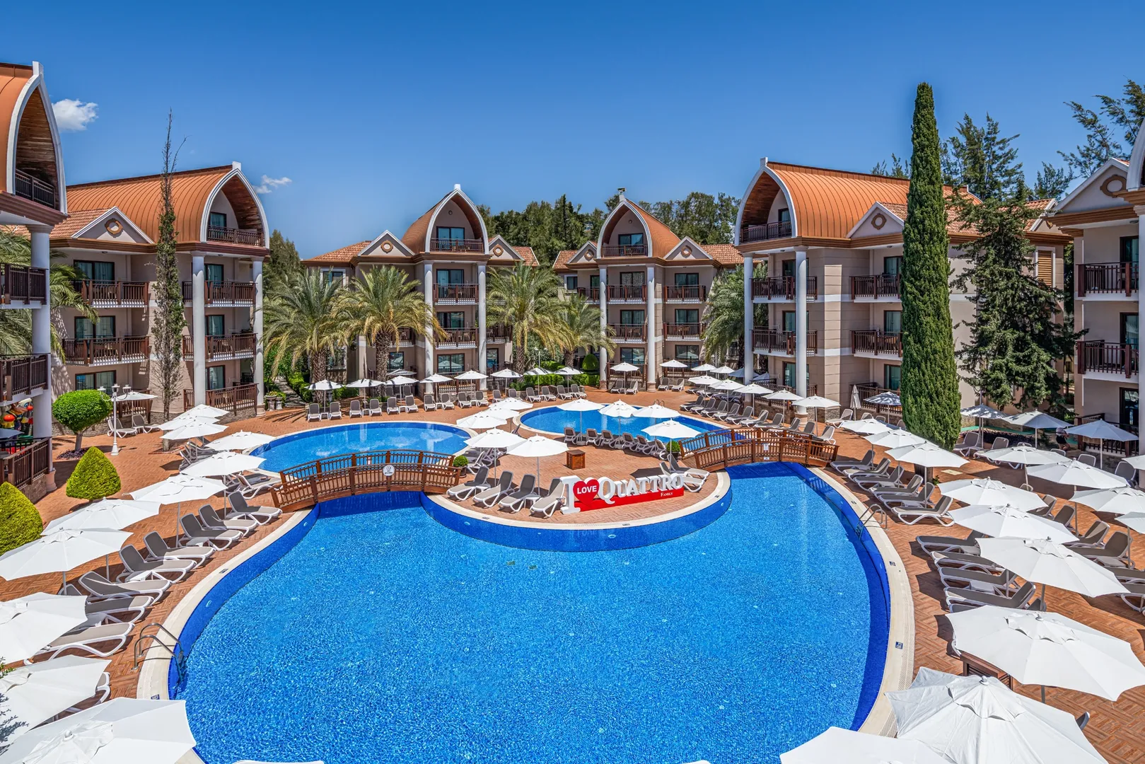 Poolanlage des Quattro Family Club Dem in Alanya mit Liegen und Sonnenschirmen