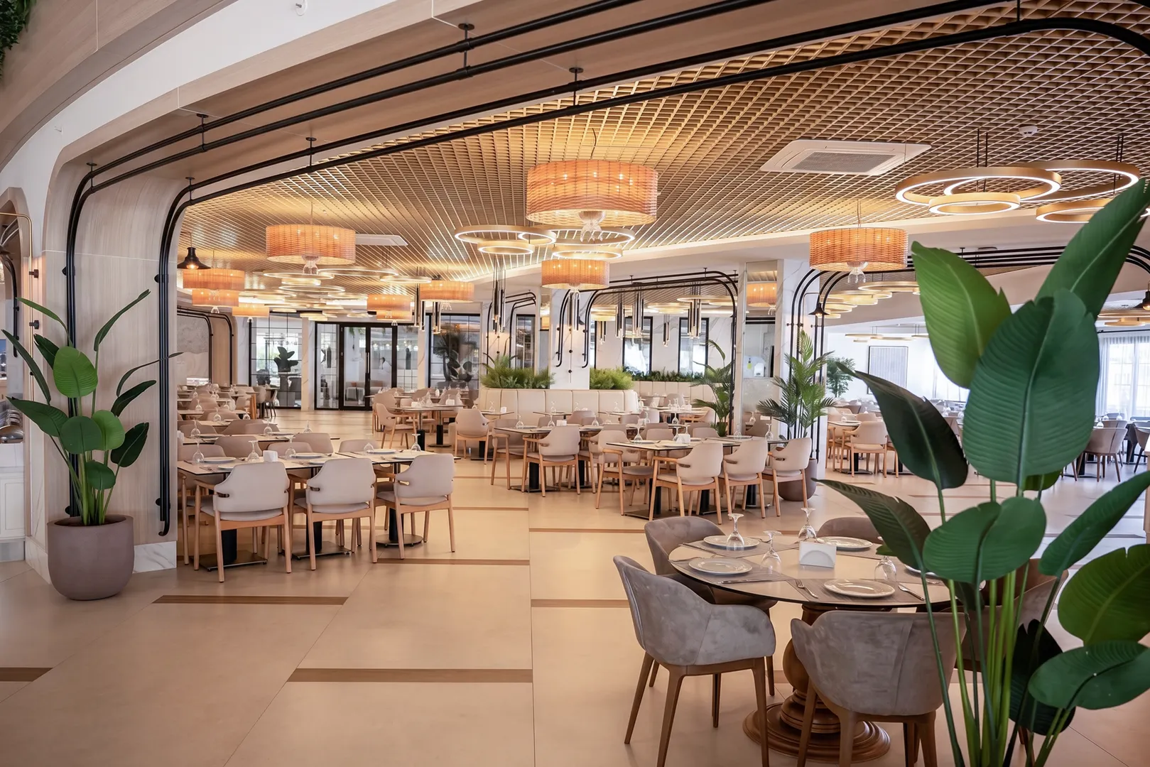 Hauptrestaurant des Quattro Family Club Dem mit Tischen und Deckenleuchten